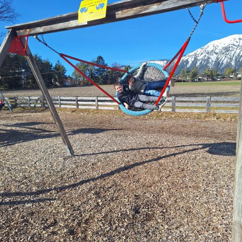 Bewegen im Freien am Spielplatz - in der Korbschaukel