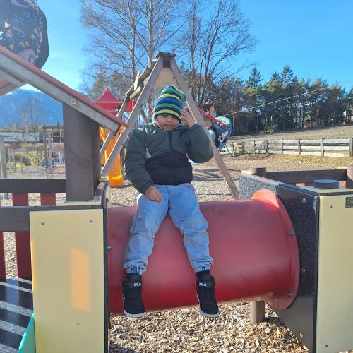 Bewegen im Freien am Spielplatz - am Tunnel des Kletterhäuschens