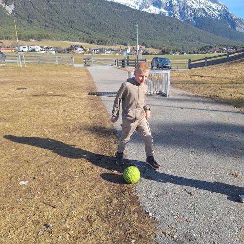 Bewegen im Freien am Spielplatz - Fußball spielen