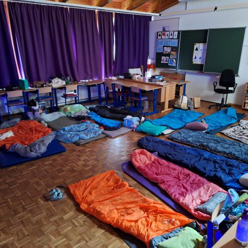 Matratzenlager mit Schlafsäcken in der Klasse